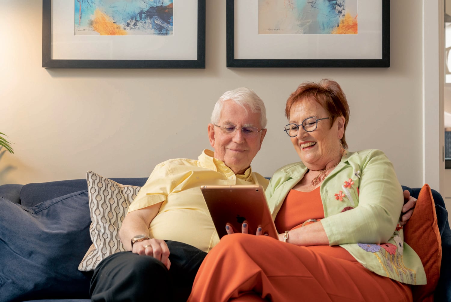 A retired couple video call with family on a tablet in their Shared Ownership home