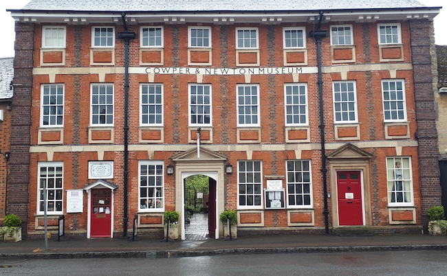a brick building with a row of doors and windows