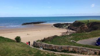 a beach with people walking on it