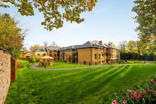 A large lawn and gardens surrounding Westwood Manor Retirement Living building.
