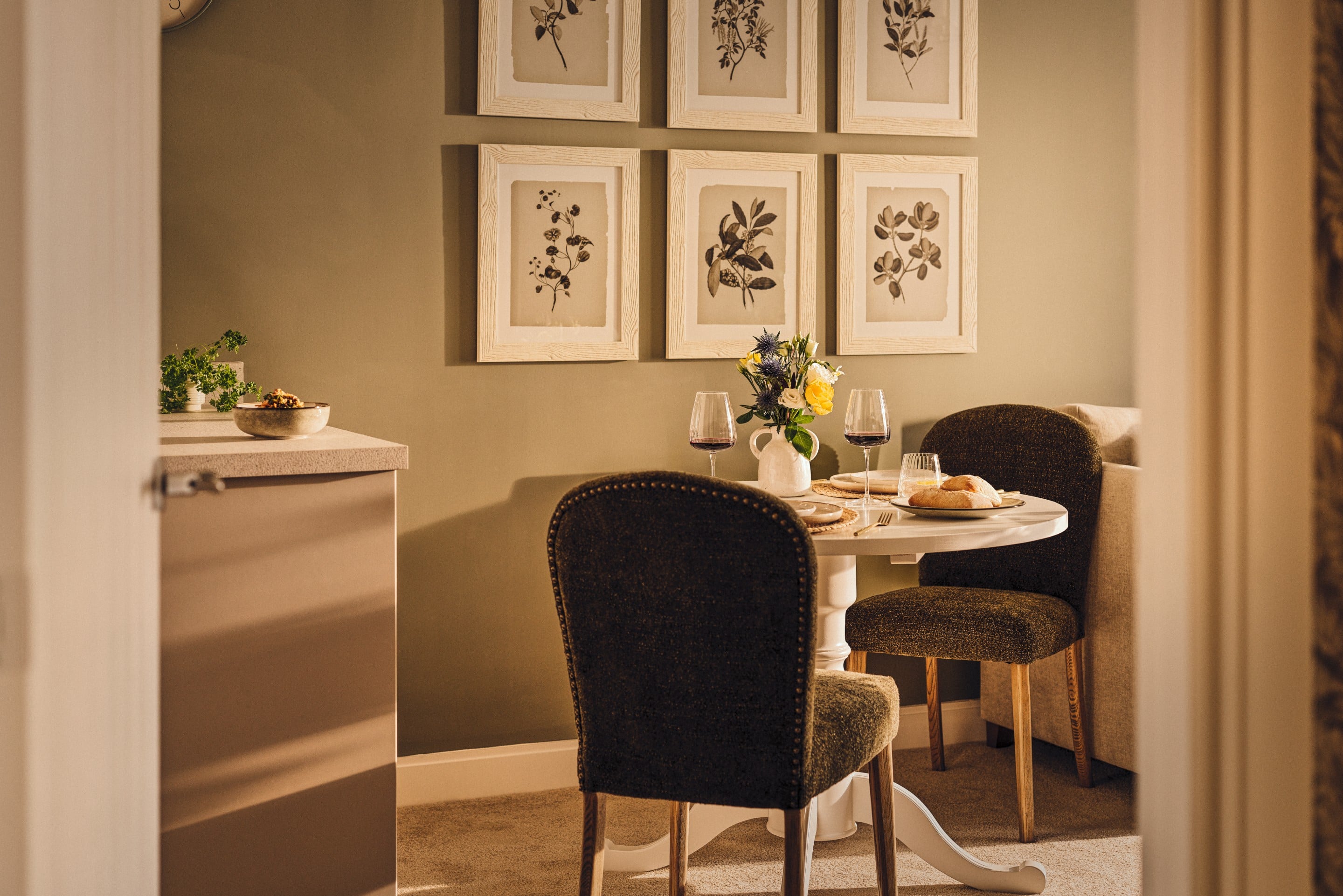 a dining table with chairs and a vase of flowers