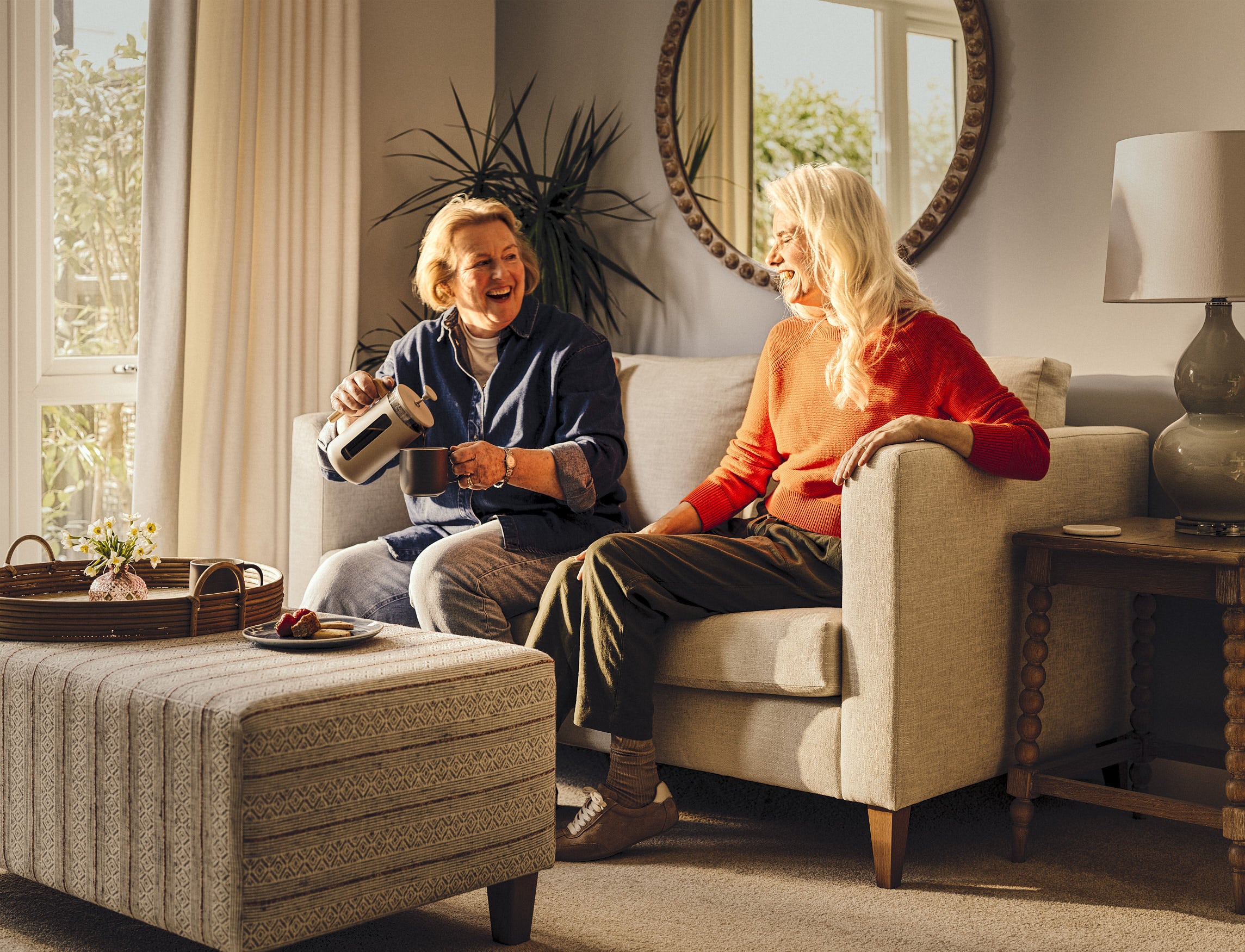 a person sitting on a couch with a person sitting on a chair