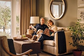 a man and a woman sitting on a couch with a dog