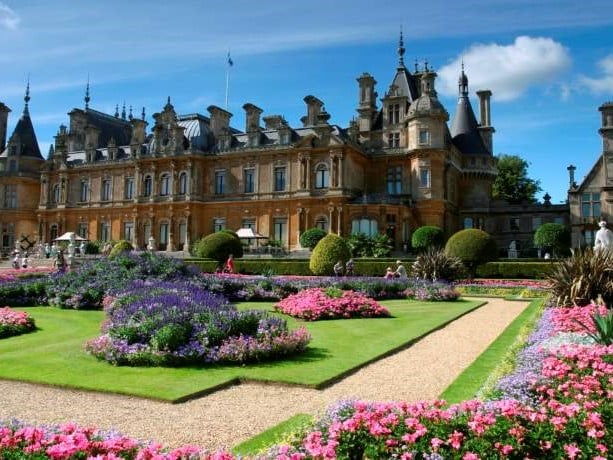 a large building with a garden in front of it with Waddesdon Manor in the background