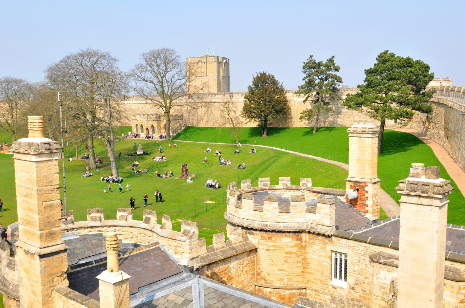 People on the lawn of Lincoln Castle surrounded by the medieval walls. 