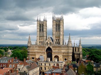 Lincoln Cathedral, with two Gothic towers and a stormy sky.