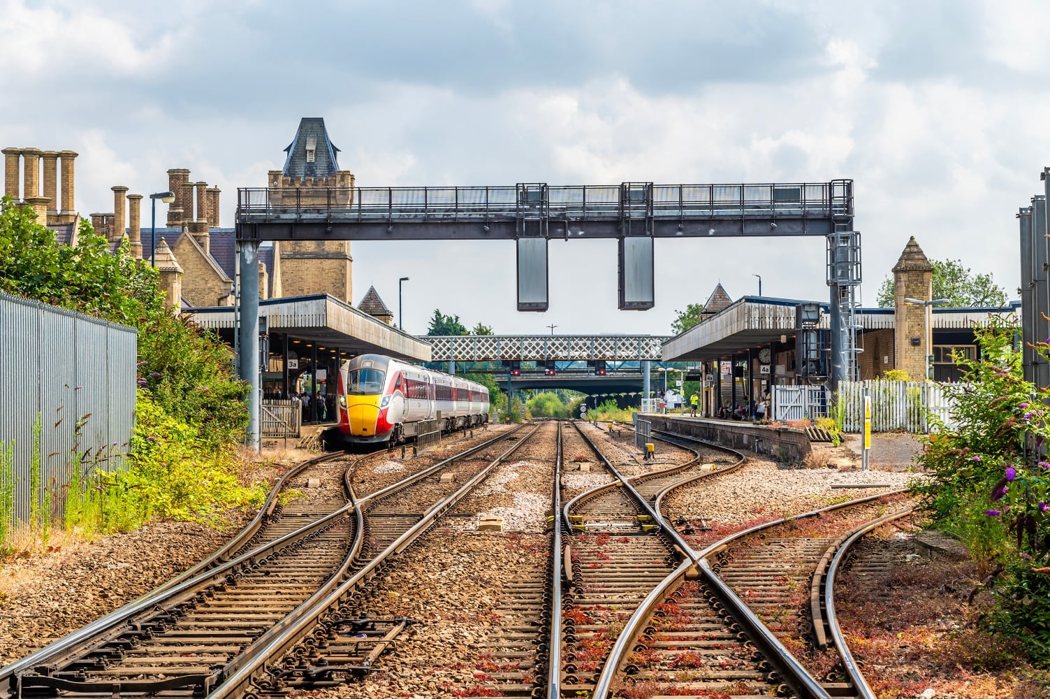 A view along the train tracks towards Lincoln railway station with a train next to one of the platforms.