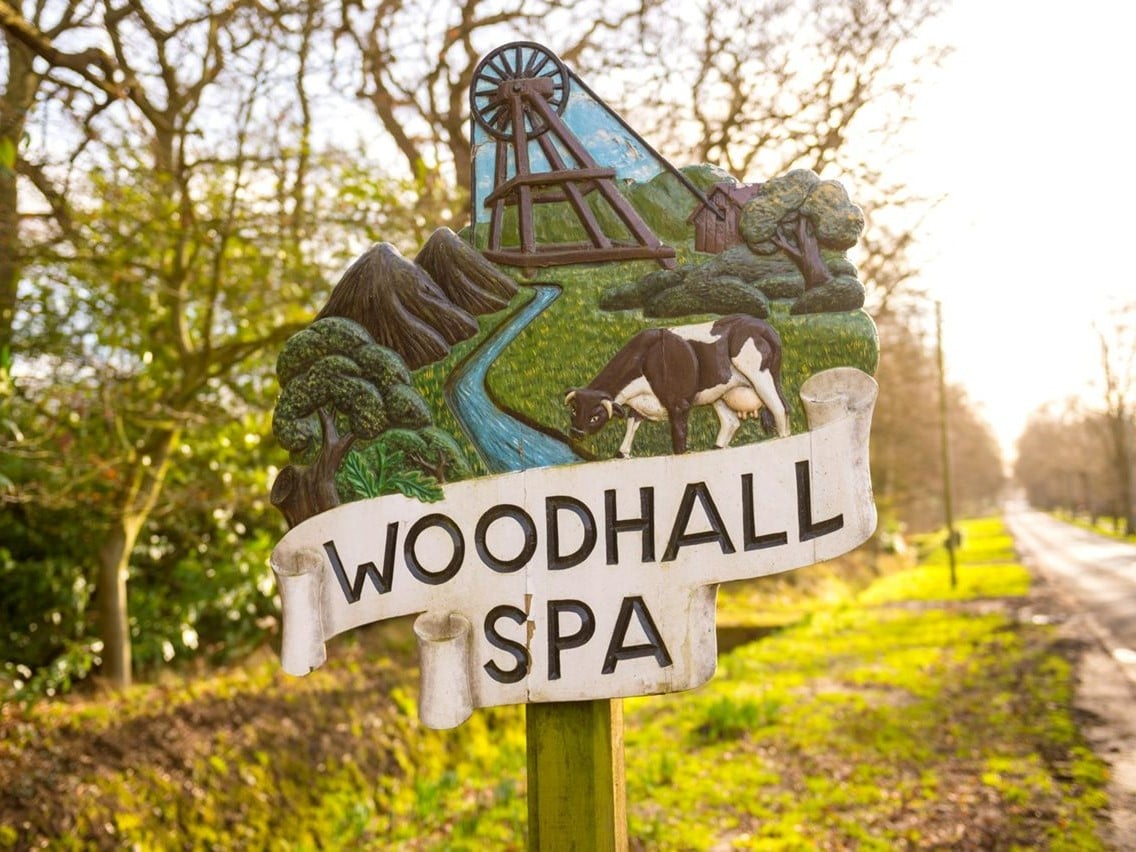 a sign with a statue of a person riding a horse