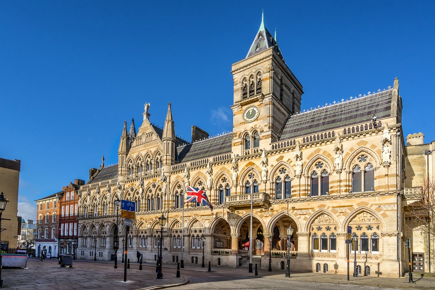 A photo of Northampton Guildhall, a Victorian brick building with many archways.