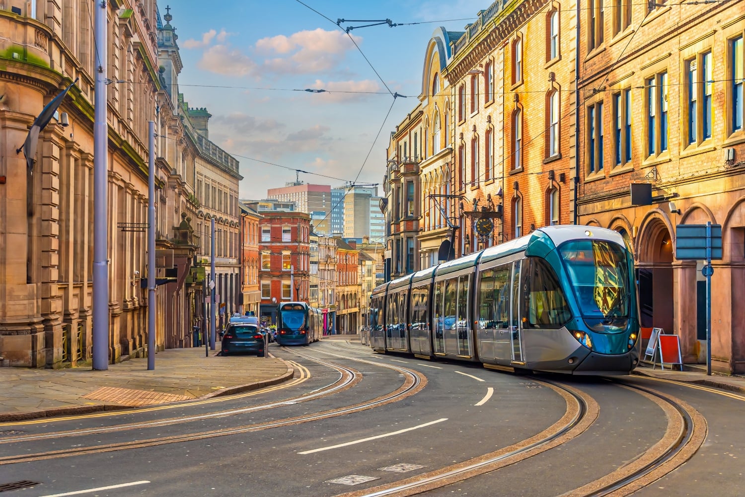 Trams moving through a city street in Nottingham.