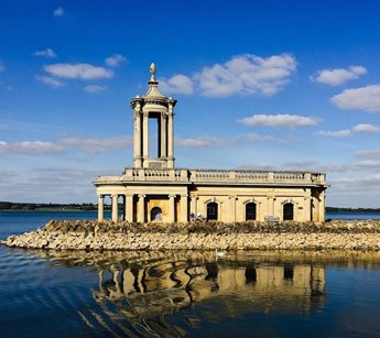a building with a tower and a body of water in the front