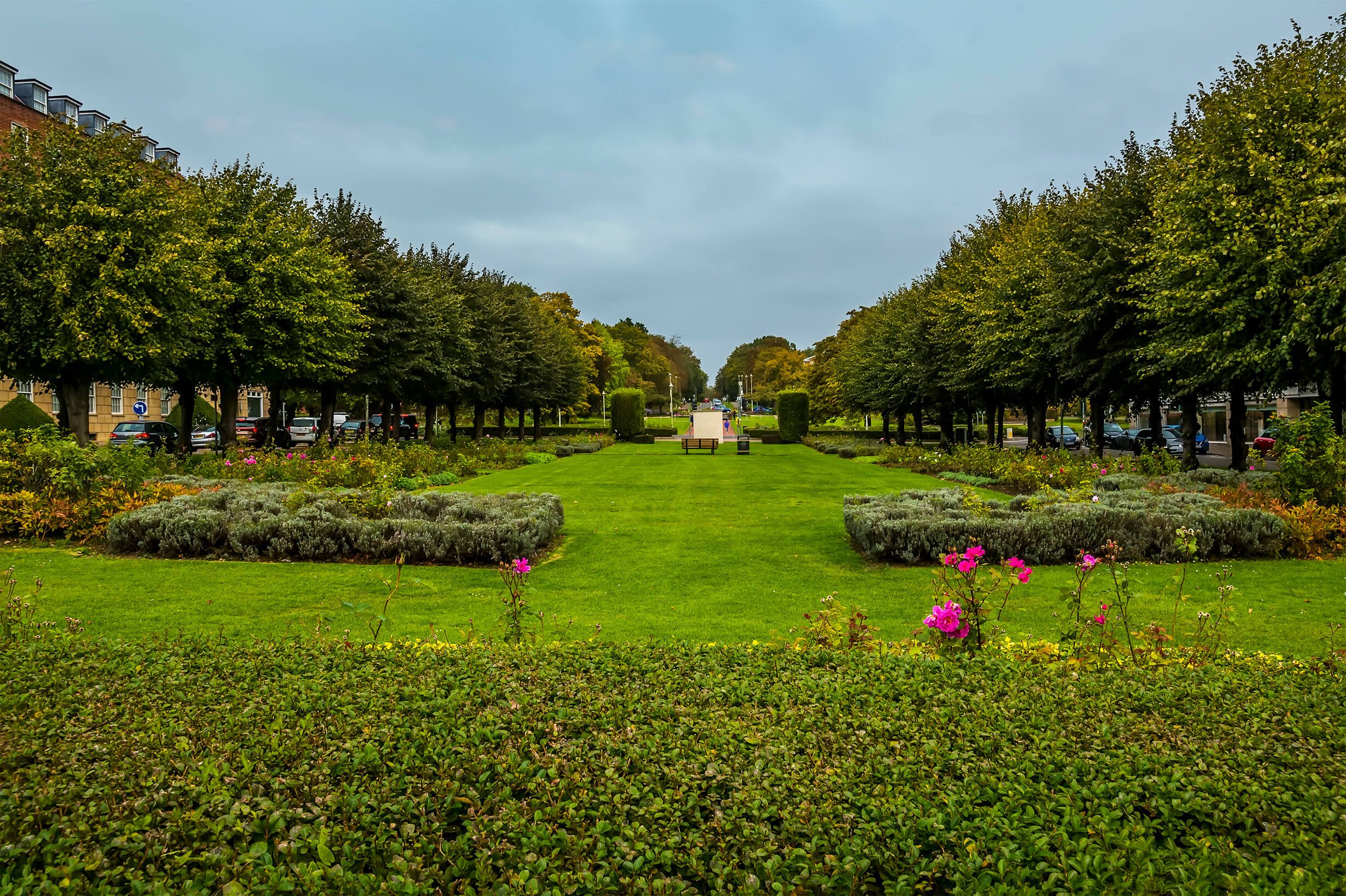 a large green lawn with trees and flowers
