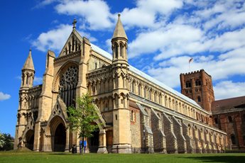 The gothic Cathedral in St Albans, set against a blue sky with a few clouds.