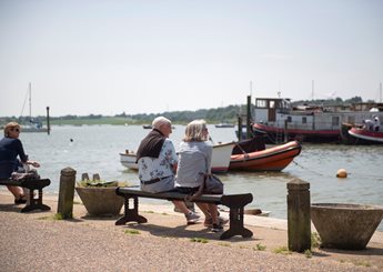 Two retirees sitting on a bench and enjoying the waterside near Martlesham Heath.