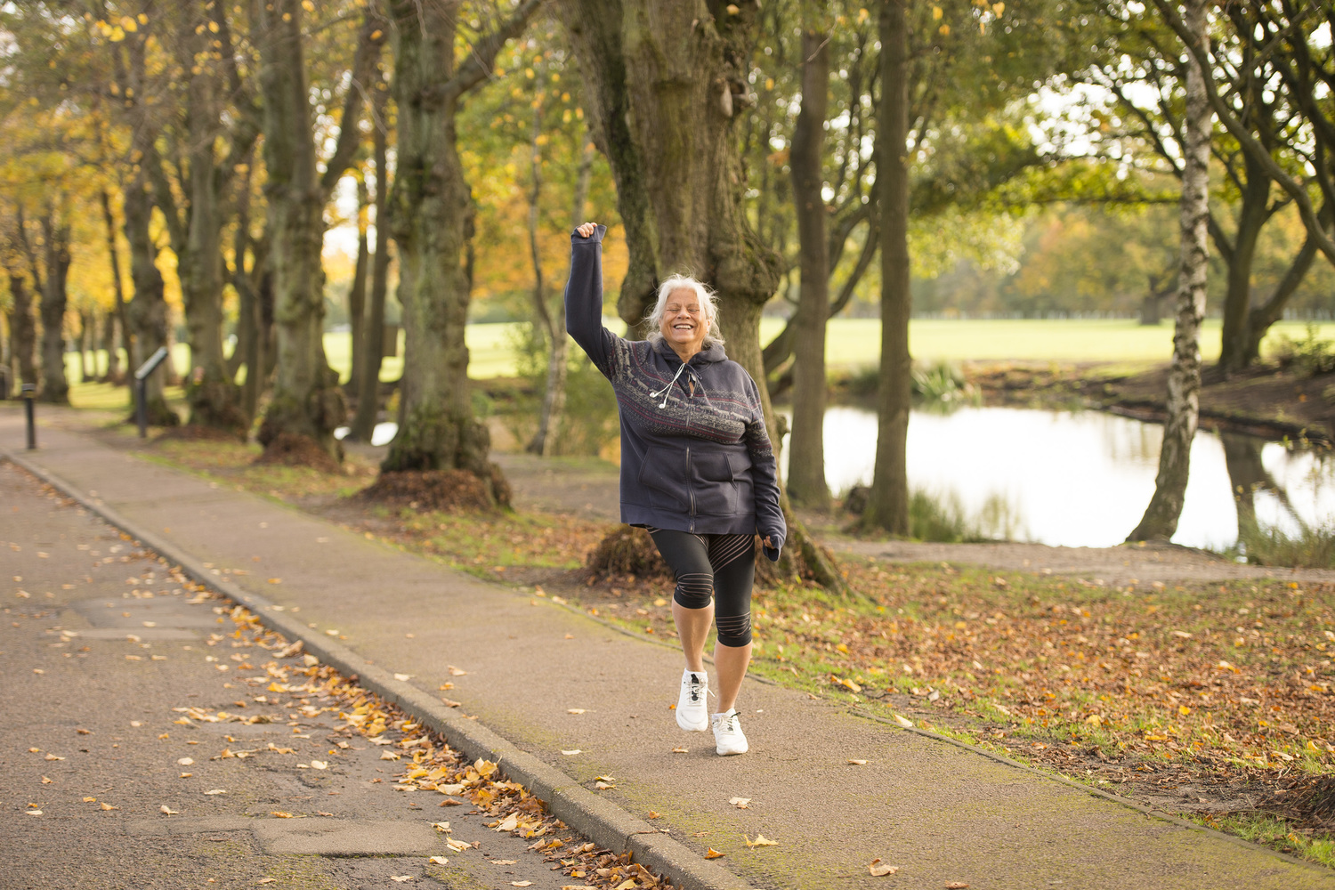 A retired lady waves to a friend while on a waterside jog in Oakwood.