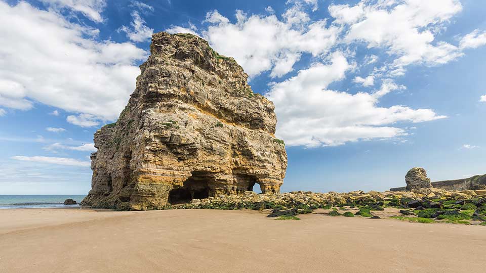 a large rock structure on a beach
