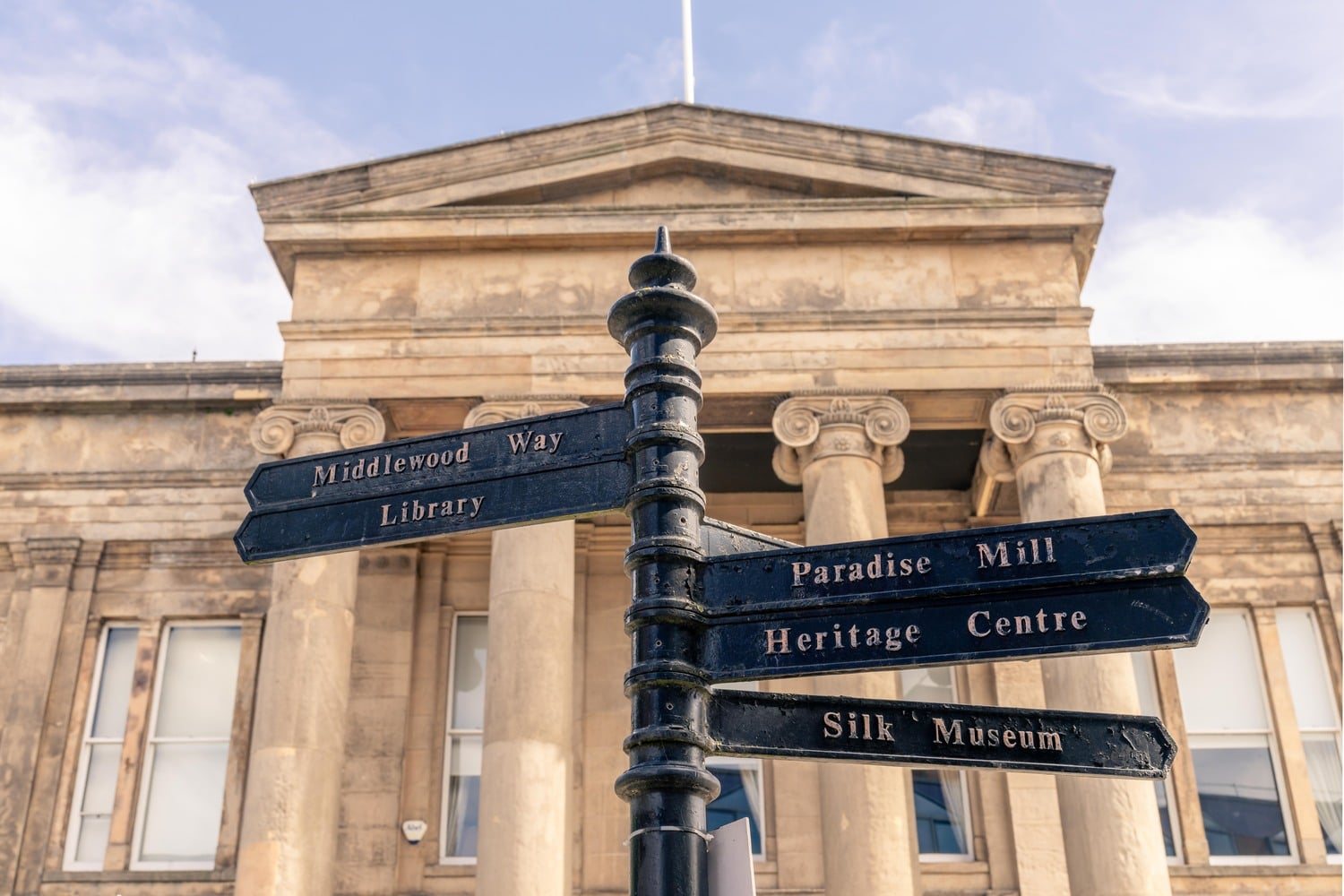 A signpost in Macclesfield centre, pointing to the library, silk museum, and heritage centre.