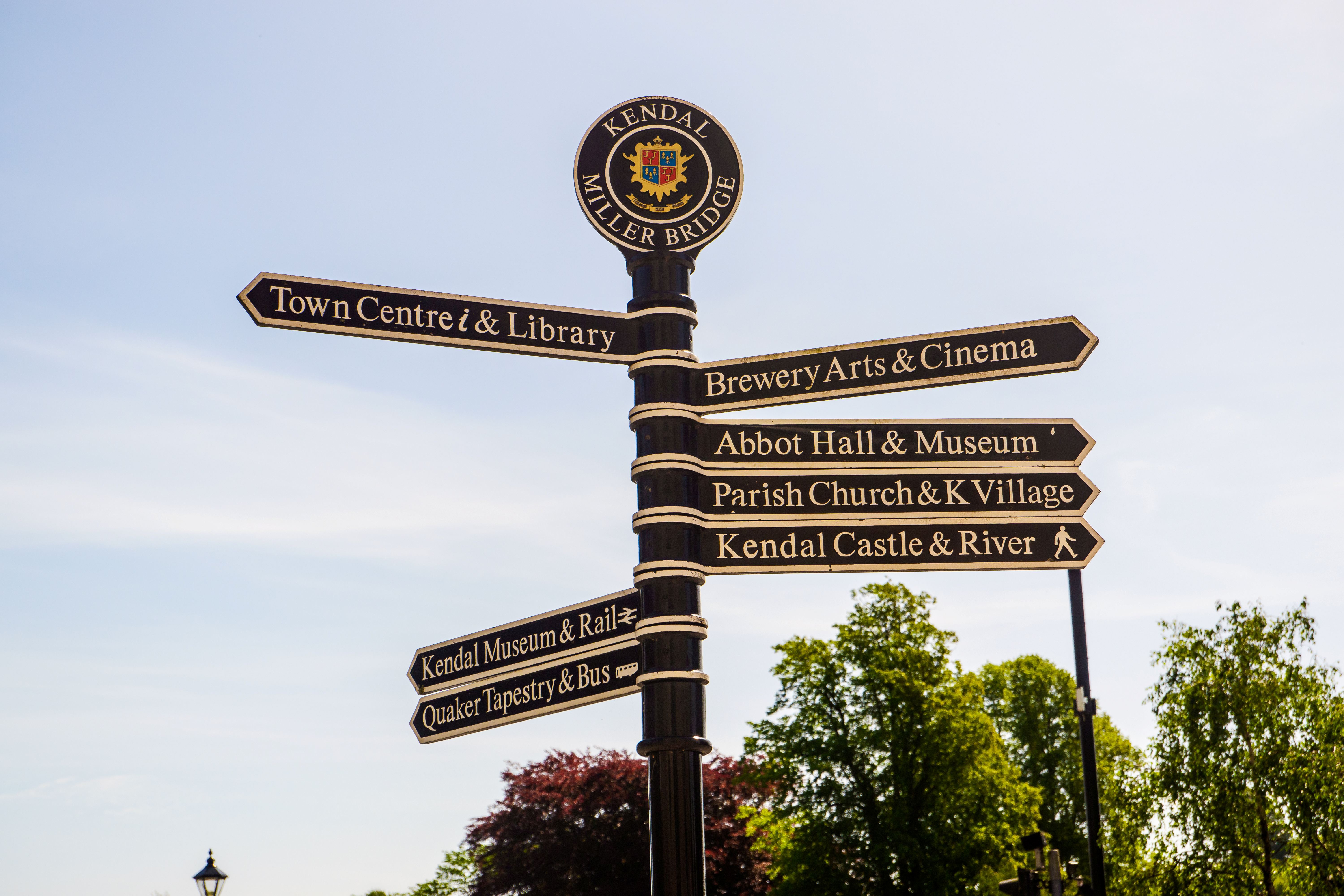 Town signpost showing directions to various places Kendal.