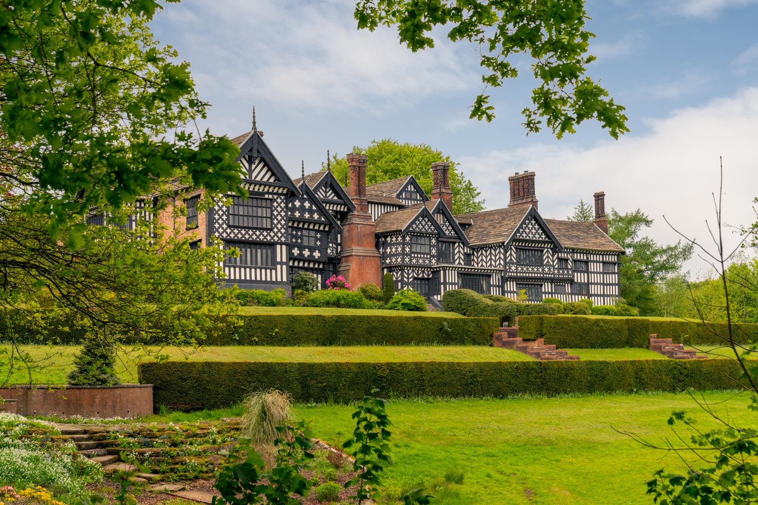 a large house with a lawn and trees in front of it