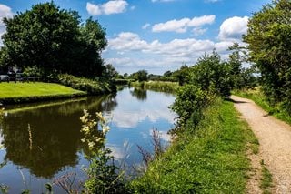 The Leeds Liverpool Canal running through Burscough in Lancashire on a sunny summer day.