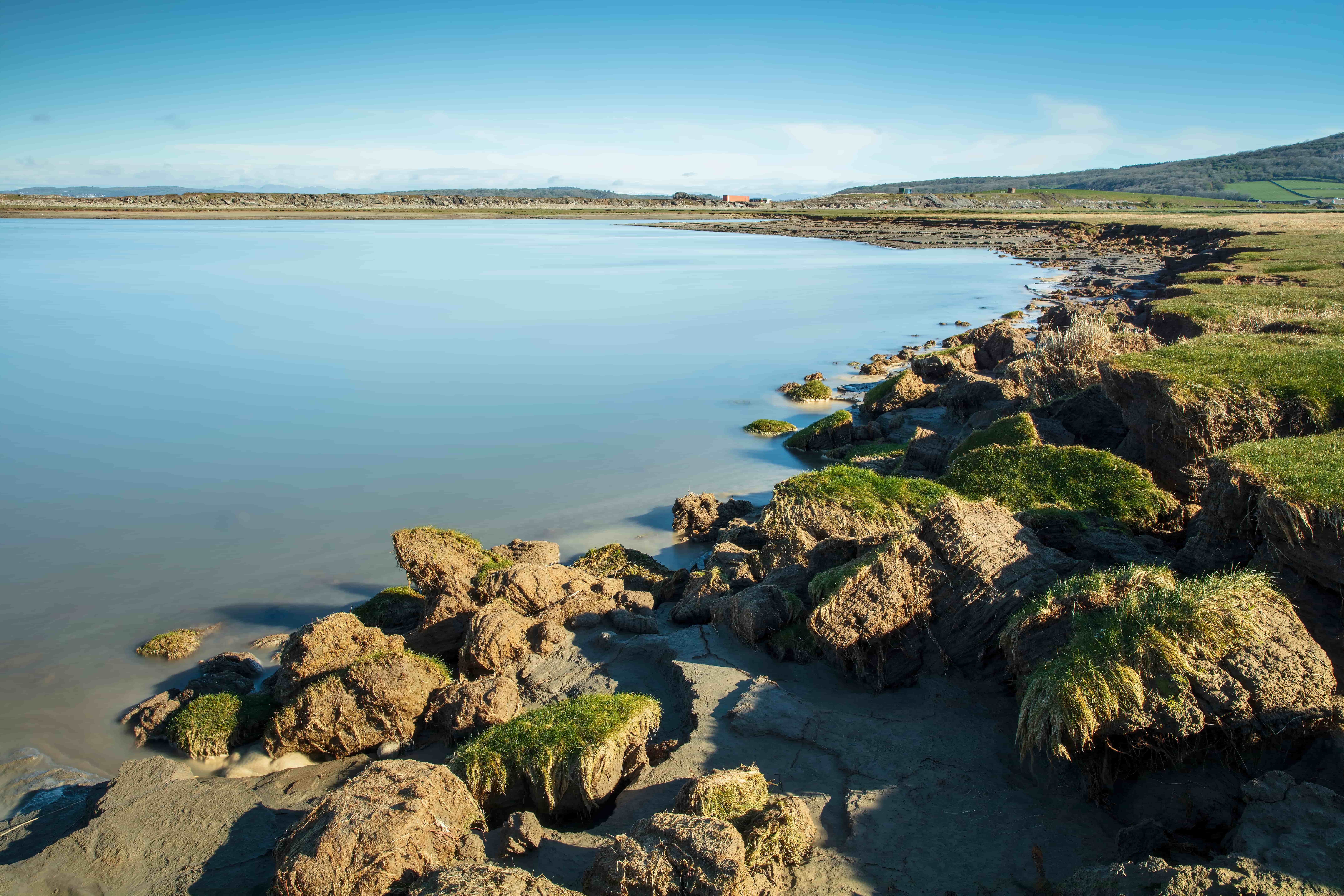 a rocky beach with a body of water in the background