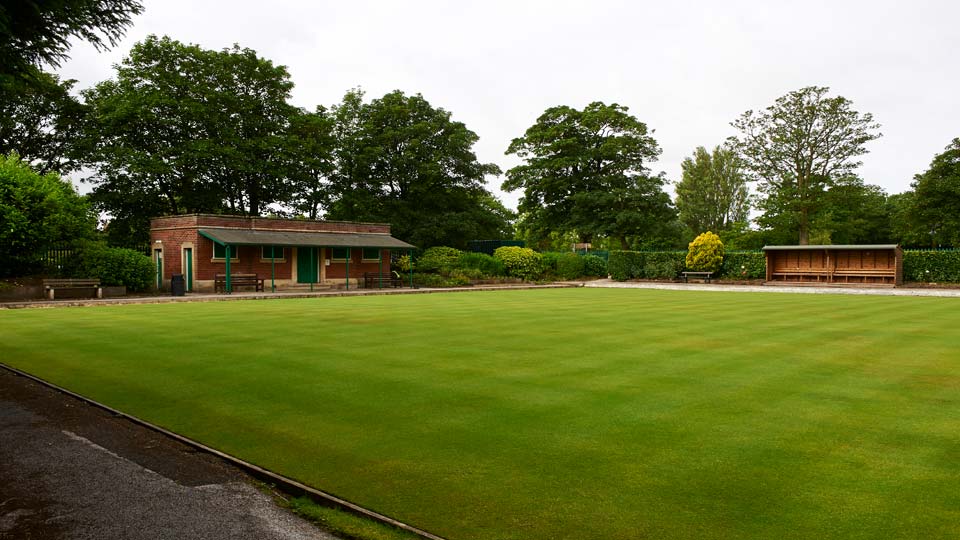 a green lawn with a building in the background