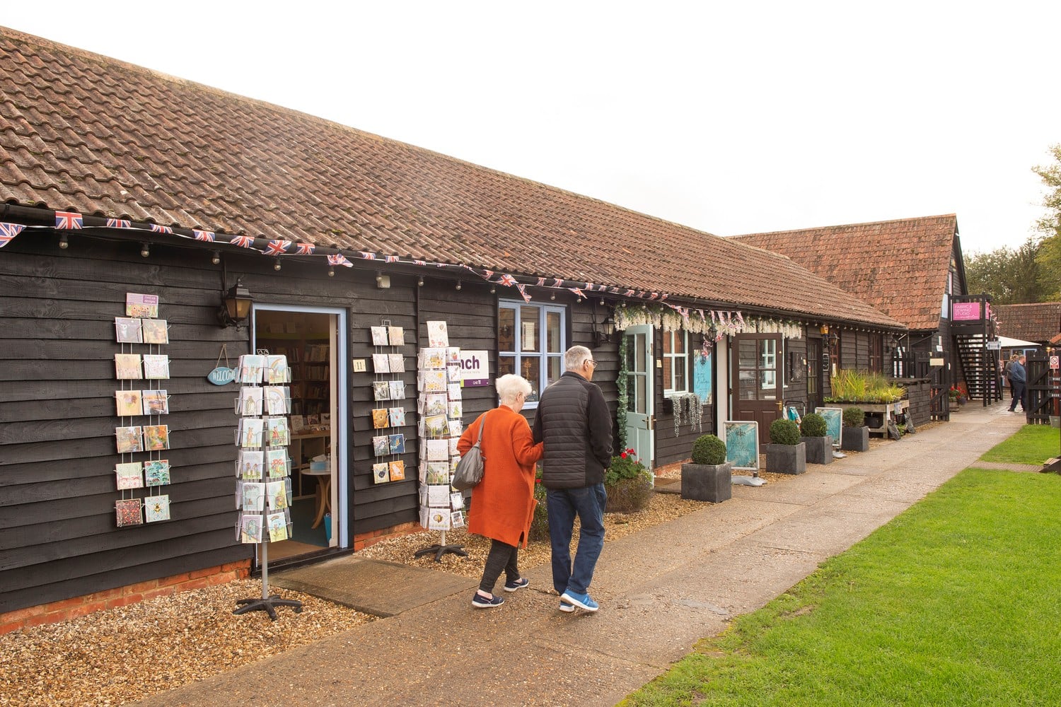 Two seniors walk outside various shops at Holme Grange Craft Centre in Wokingham.
