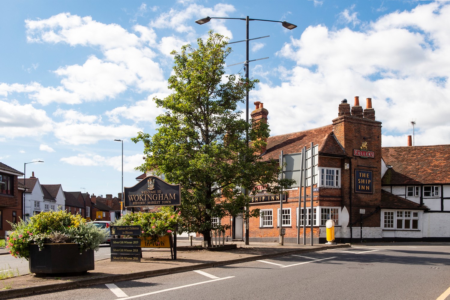 Street entrance of Wokingham with a welcome sign and local pub.