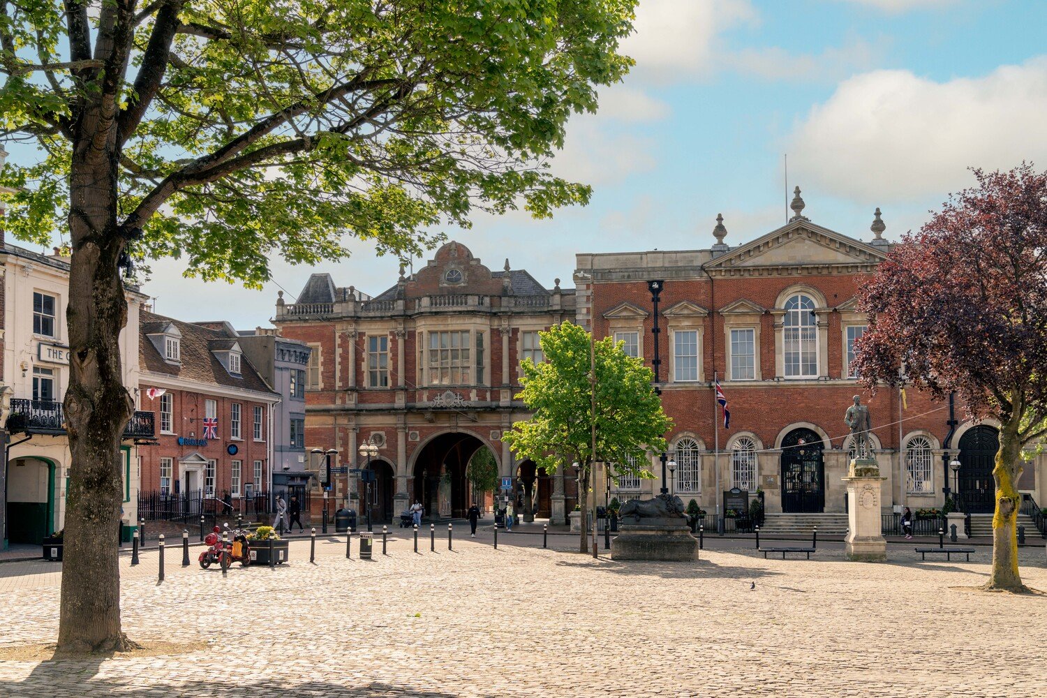 A courtyard in Aylesbury town centre, ringed with red brick buildings on a sunny day.