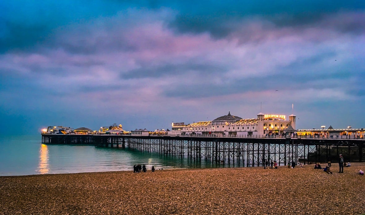 Brighton Palace Pier in Brighton seen from the beachfront during twilight hours.