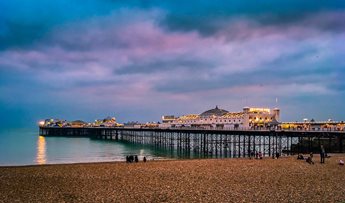 Brighton Palace Pier in Brighton seen from the beachfront during twilight hours.