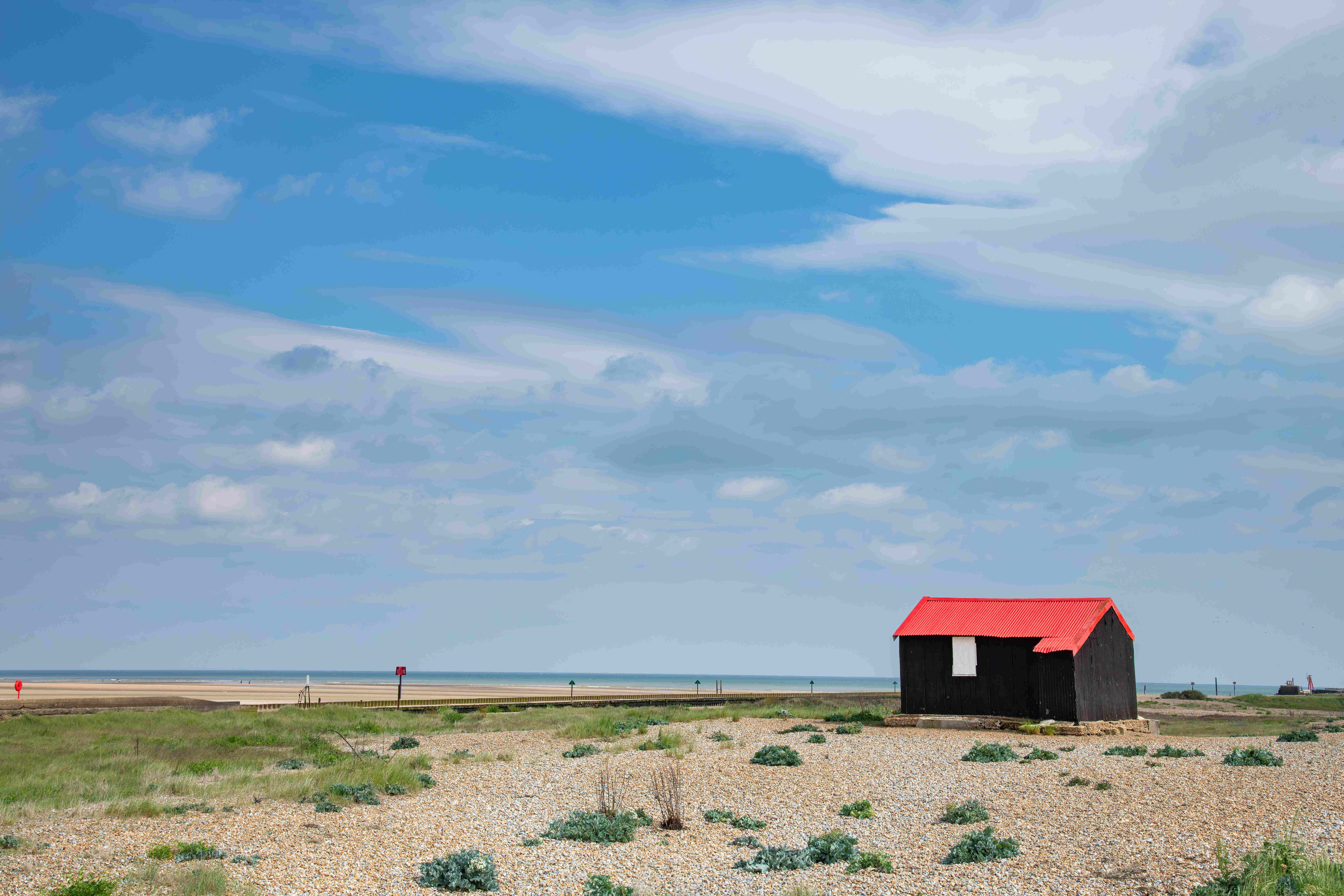 A red roofed hut on the Rye Harbour estuary in East Sussex.