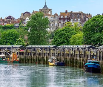 A row of fishing boats docked along the river in Rye.