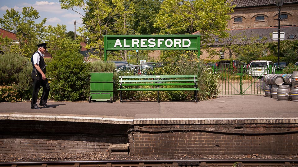 a man standing next to a green bench