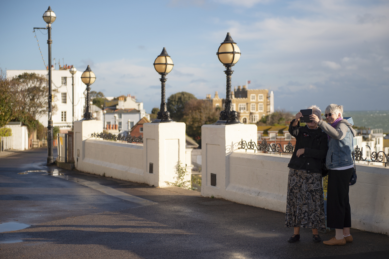 Two retired ladies taking photos in the streets of Broadstairs, Kent.