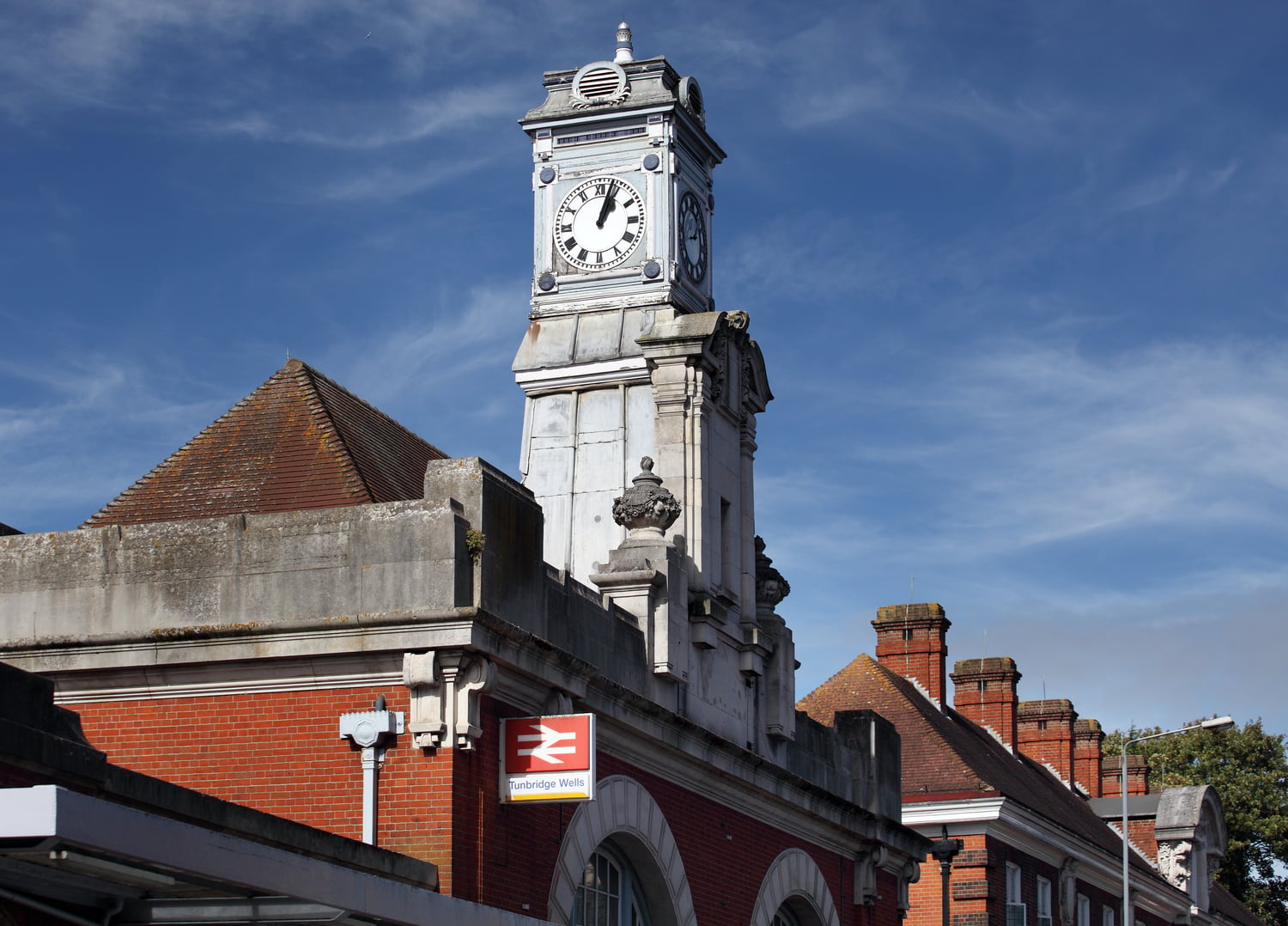 A clock tower on top of Tunbridge Wells train station building.