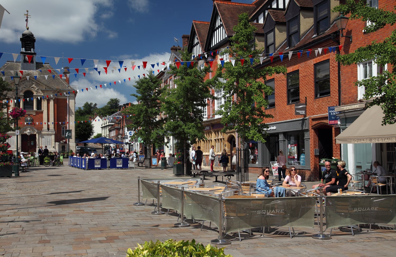 Henley-on-Thames town centre with people sitting outside at tables.