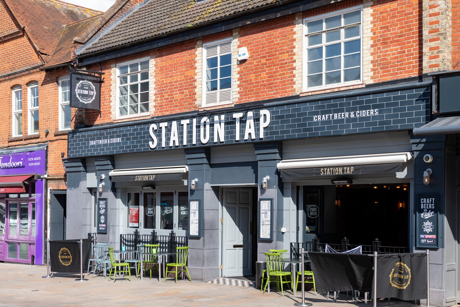 A bar in Bagshot town centre with chairs and tables in the foreground.