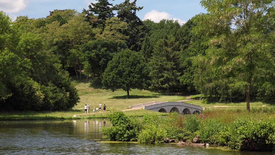 a group of people walking on a path by a body of water