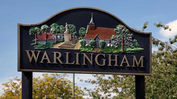 a sign with a building in the background