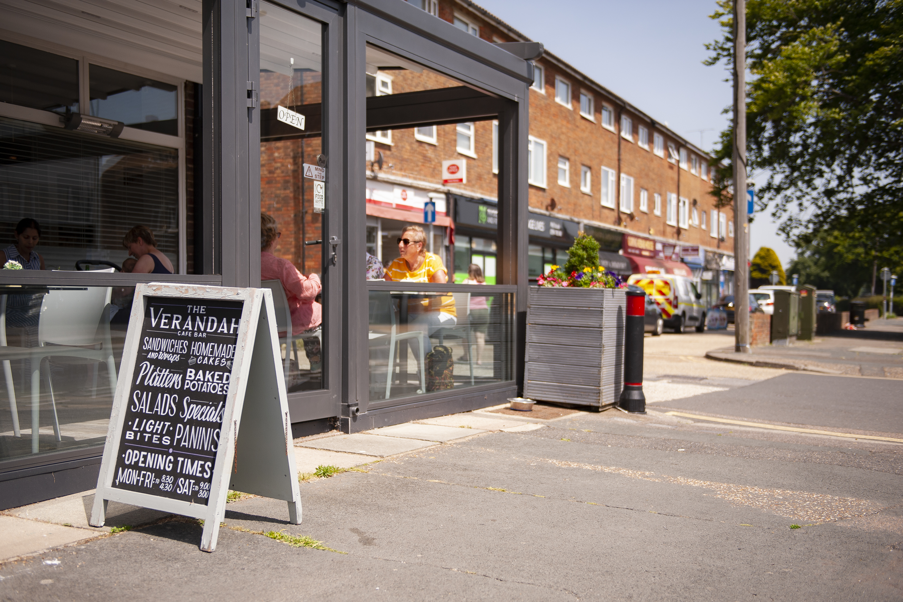 A shot of Goring Highstreet next to a local café with an a-frame board outside showing what's for sale in the café.