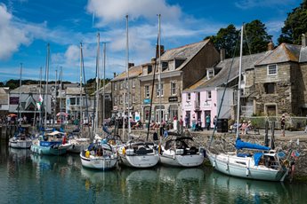 Boats docked at Padstow Harbour with old buildings in the background.