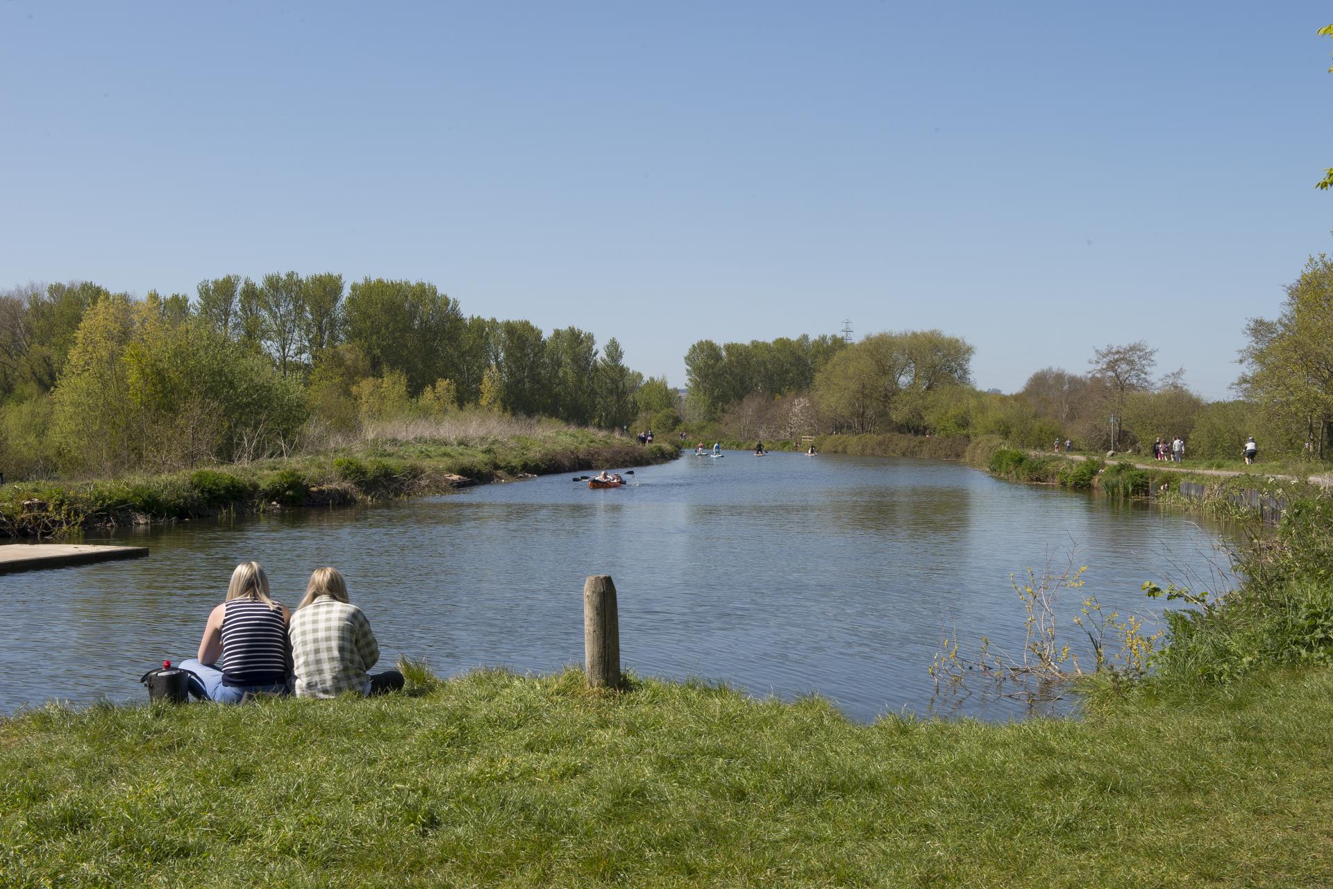 a couple sitting on a bench by a lake