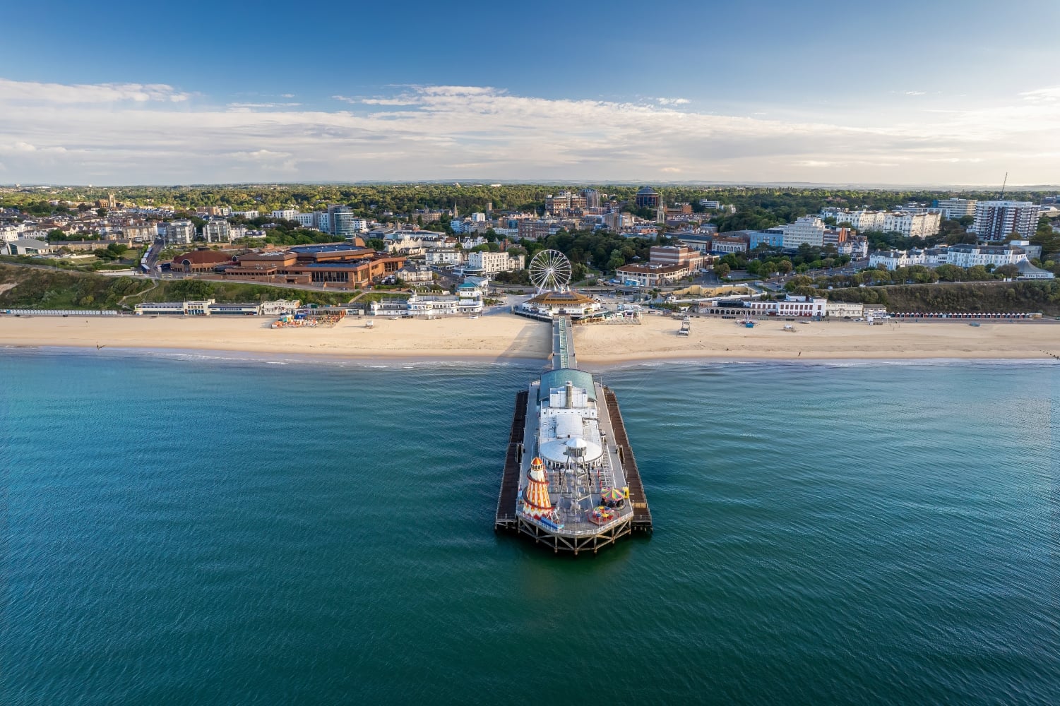 An aerial view of Bournemouth Pier from the sea with the town and beach in the background.