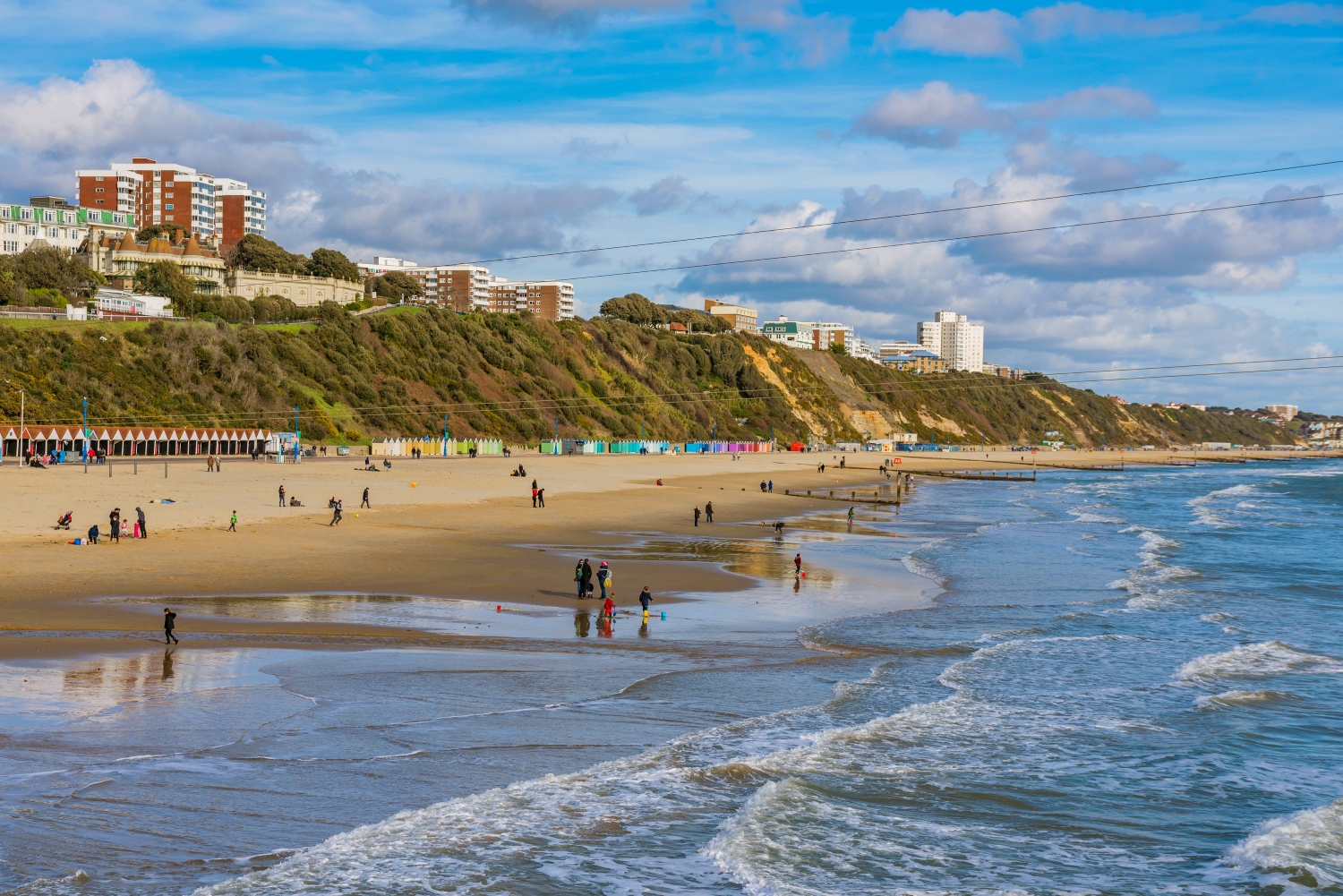 People on Bournemouth beach on a sunny day.