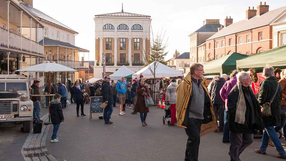 a crowd of people at an outdoor market
