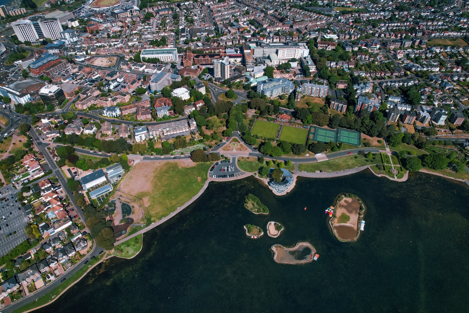 Aerial photograph of Poole Park showcasing its lakeside setting, sports facilities and open green space.