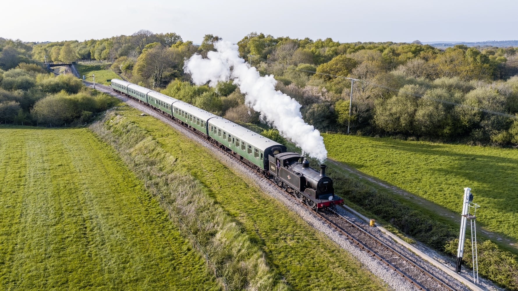 An aerial view of a steam train on the Swanage Railway near Corfe Castle.