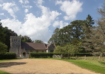 A church with a fence and trees around it close to the market town of Wimborne.
