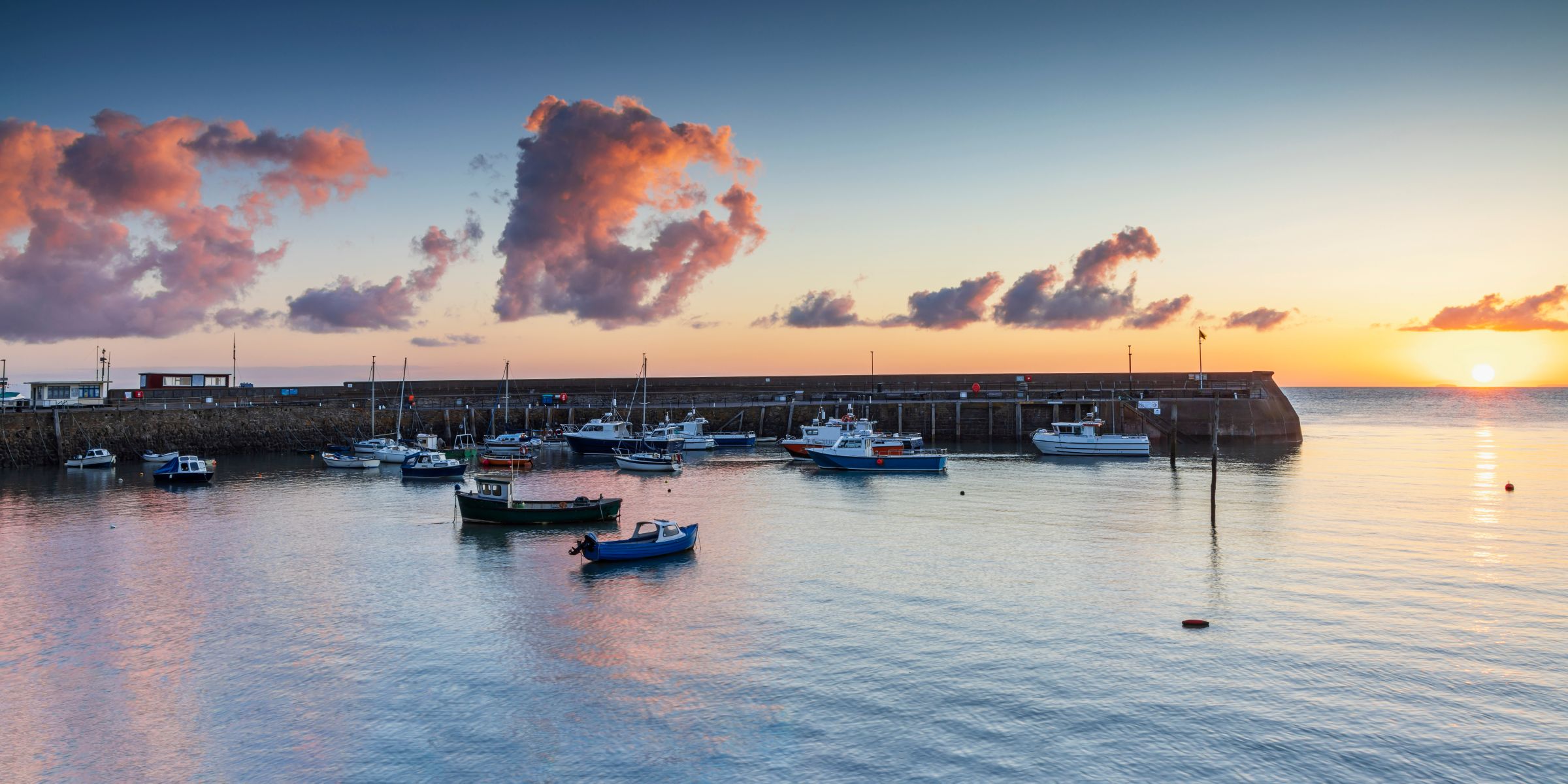 a group of boats in Minehead Harbour at sunrise